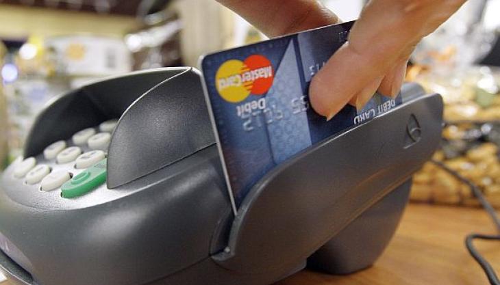 imagen de un datafono pasando una tarjeta de crédito tras una compra