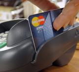 imagen de un datafono pasando una tarjeta de crédito tras una compra